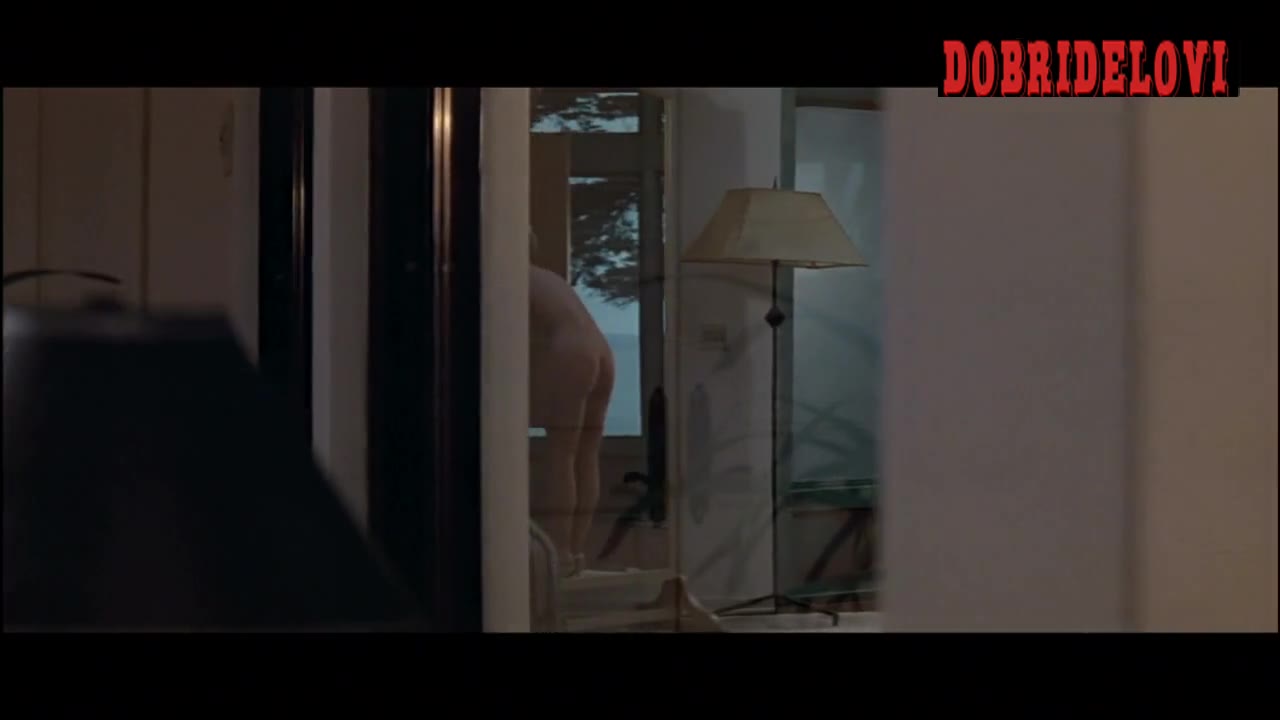 Sharon Stone getting dressed while Michael Douglas peeps through a mirror