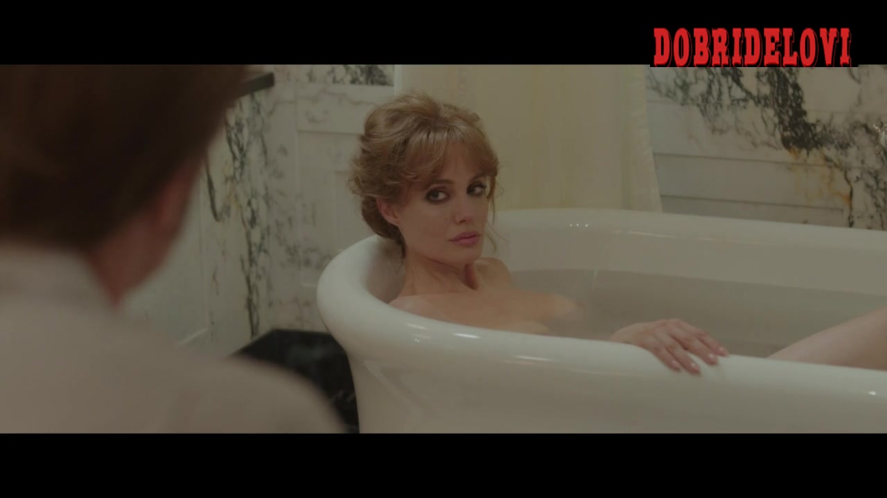 Angelina Jolie sits in the bathtub with exposed breasts
