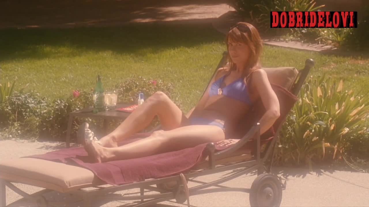 Kristen Wiig sunbathing in lounge chair scene from Extract